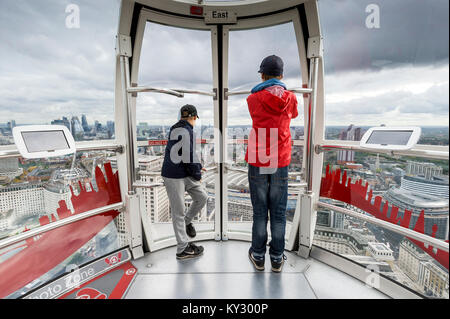 two boys look out of the window of London`s Big Eye Stock Photo